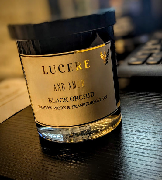 Lucere & Amor Black Orchid candle — Shadow Work & Transformation, in a dark glass vessel with gold label and phoenix motif